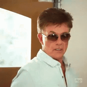 a man wearing sunglasses is making a funny face .