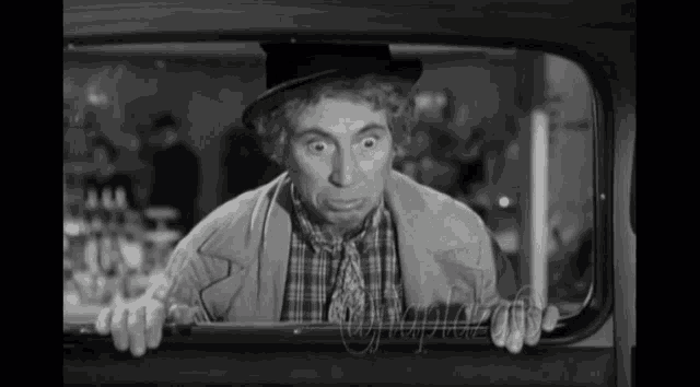 a black and white photo of a man in a hat and plaid shirt