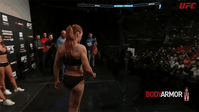 a woman stands on a scale in front of a crowd and says peso oficial : 56,4 kg para a campea