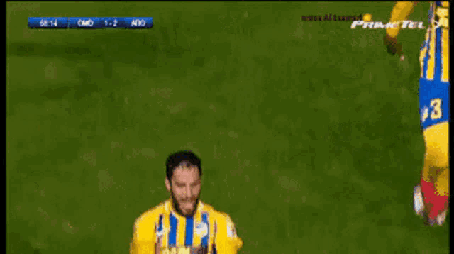 a soccer player wearing a yellow and blue striped shirt with part match on it
