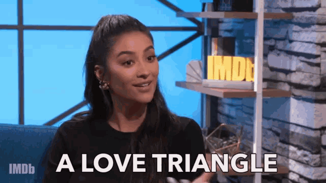 a woman sitting on a couch with the words " a love triangle " on the screen