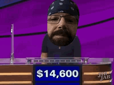 a man with glasses and a bandana stands in front of a $ 14,600 sign
