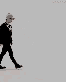 a person wearing a hat and a black jacket is dancing .