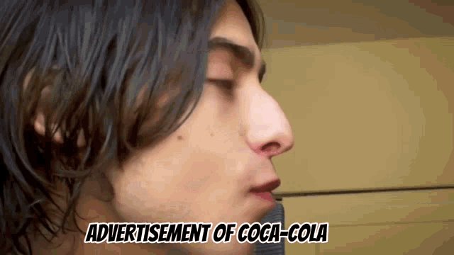a close up of a man 's face with the words advertisement of coca-cola below