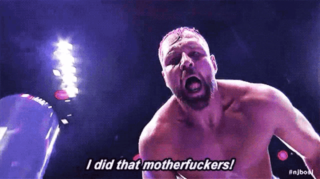 a shirtless man is standing in a boxing ring with his mouth open and yelling .