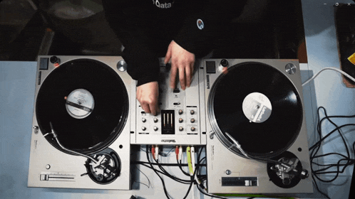 a person playing records on technics turntables