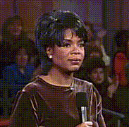 a woman is singing into a microphone while holding her hair