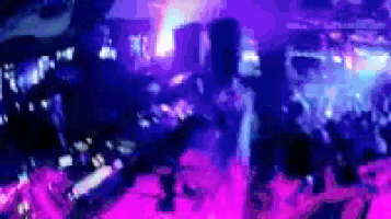 a blurry picture of a crowd of people at a concert in a club .