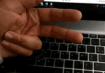 a close up of a person 's hand pressing a key on a laptop keyboard