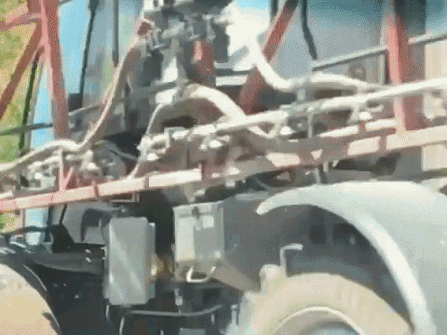 a close up of a tractor spraying a field with a hose attached to it .