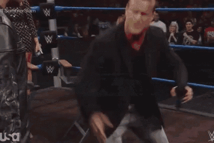 a blurred image of a crowd watching a wrestling match in a stadium .
