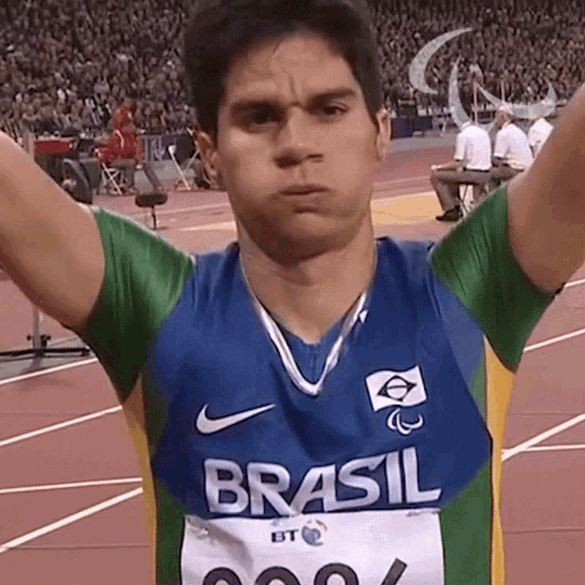 a man wearing a shirt that says brasil is standing on a track