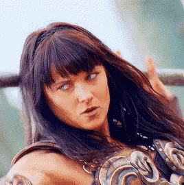 a close up of a woman 's face with a sword in her hand