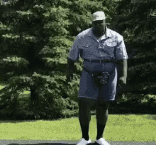 a man wearing a hat and shorts is standing on a sidewalk
