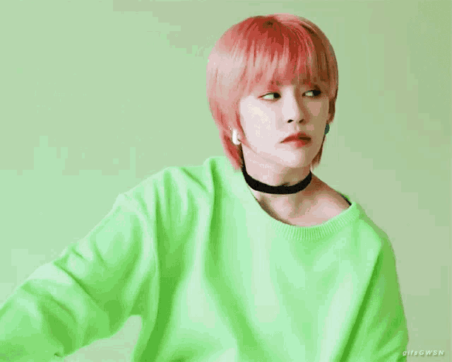 a woman wearing a green sweater and a choker has the word gifsgwsn on the bottom right