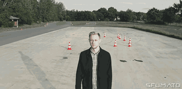 a man in a black jacket stands in the middle of a road with sfumato written on the bottom of the screen