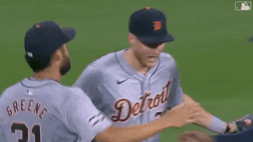 a group of baseball players hugging each other on the field