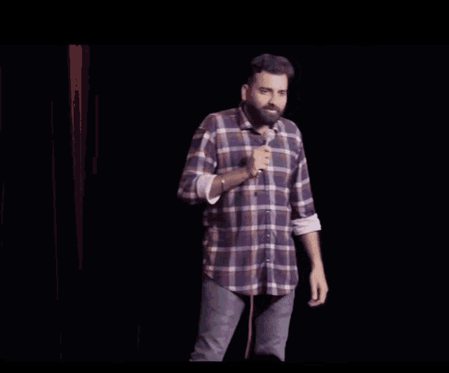 a man stands in front of a microphone with the words ye itna genius ladka behind him