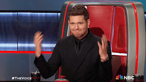 a man in a suit and tie is sitting in a chair with a nbc logo on it