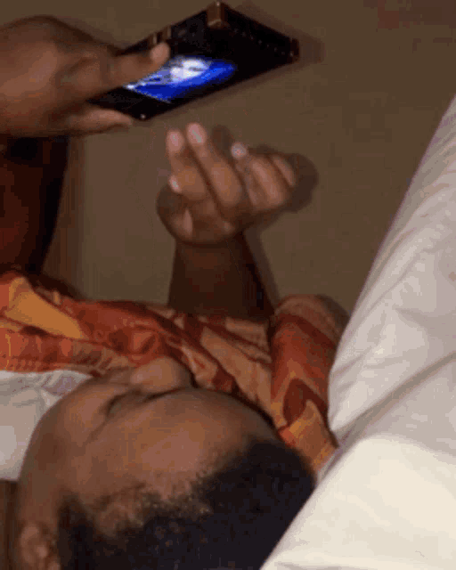 a person is laying on a bed looking at a phone