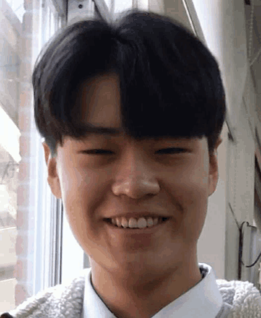 a close up of a young man 's face with a smile