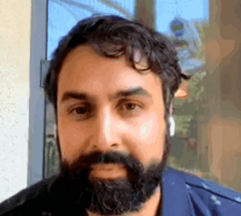 a man with a beard is wearing headphones and looking at the camera