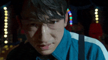 a close up of a man 's face with a tear running down his cheek .