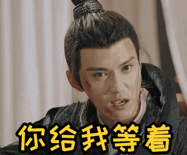 a man with chinese writing on his face and a ponytail