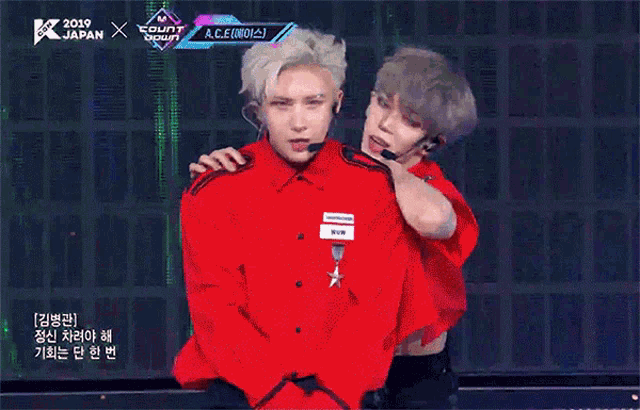 a man in a red shirt is being held by another man in a red shirt ..