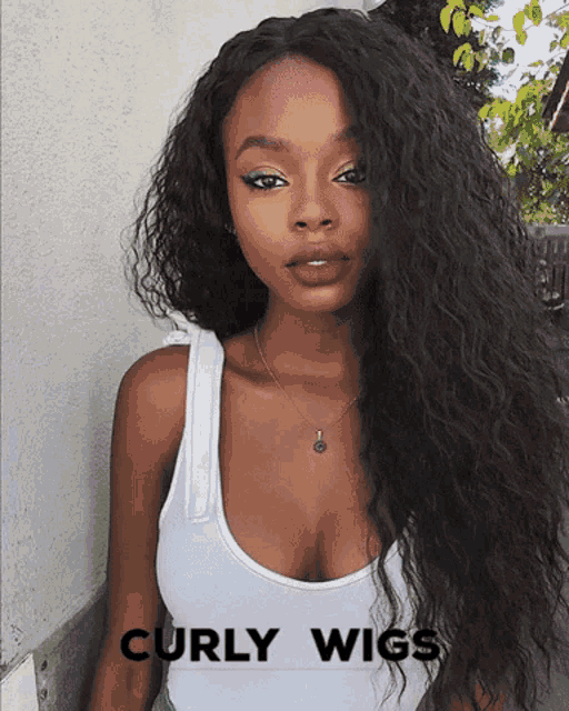 a woman with curly hair is wearing a white tank top and a necklace