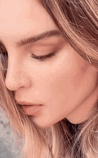 a close up of a woman 's face with closed eyes