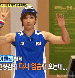 a man wearing a blue tank top and a blue hat is waving his hand .