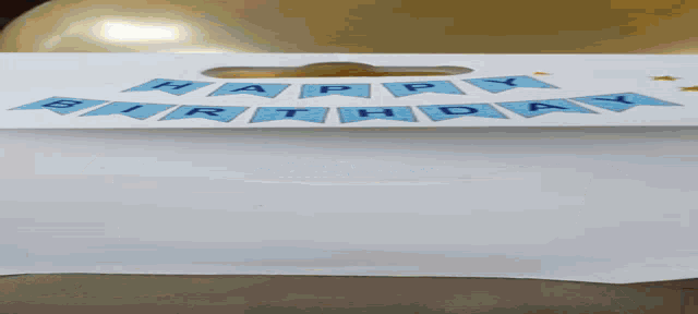 a happy birthday banner hangs from a balloon in a package