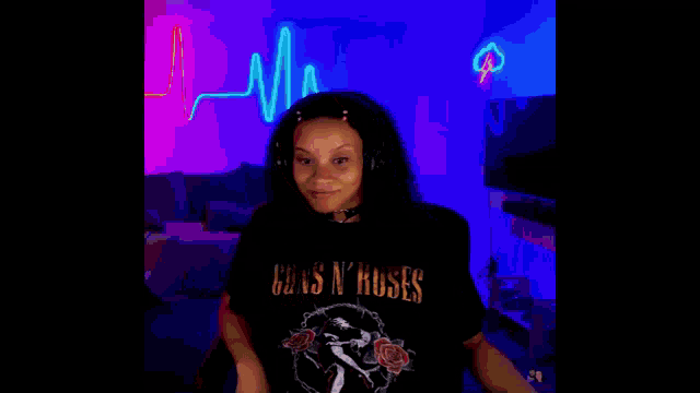 a woman wearing headphones is giving a high five in a room with purple lights .
