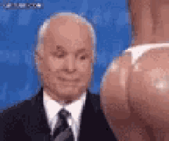 a man in a suit and tie is looking at a woman 's butt on a blue background .