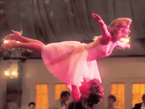 a woman in a pink dress is being lifted in the air