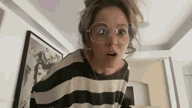 the woman is wearing glasses and a striped shirt .