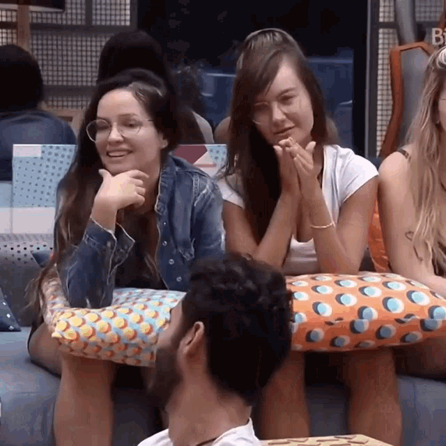 a group of people are sitting on a couch and one of them has glasses