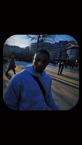 a person wearing a shirt that says ' a ' on it is walking down the street