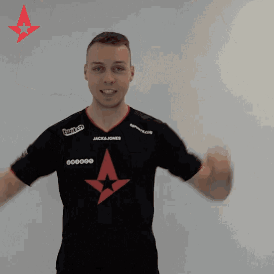 a man wearing a black shirt with a red star on it is flexing his muscles