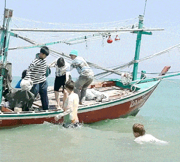 a group of people standing on top of a boat that has the number 3 on it