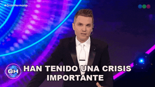 a man in a suit and tie is standing in front of a purple and blue background with the words han tenido una crisis importante