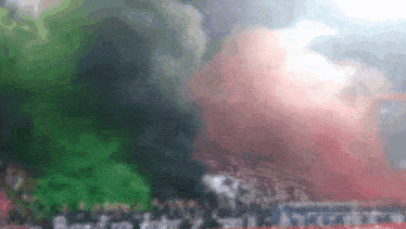 a blurred image of a crowd of people with smoke coming out of them