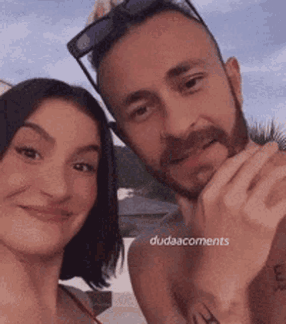 a man and a woman are posing for a picture with dudaacoments written on the bottom