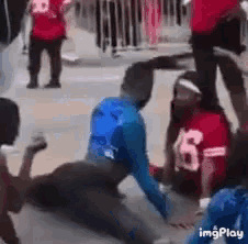 a man in a blue shirt with the number 15 on his back is laying on the ground .