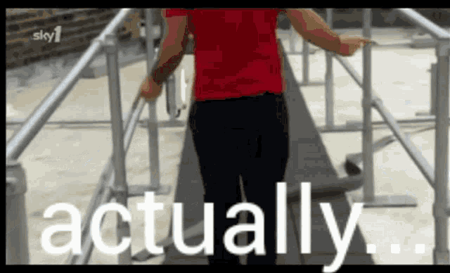 a man in a red shirt is walking down a set of stairs with the words " actually " in white letters