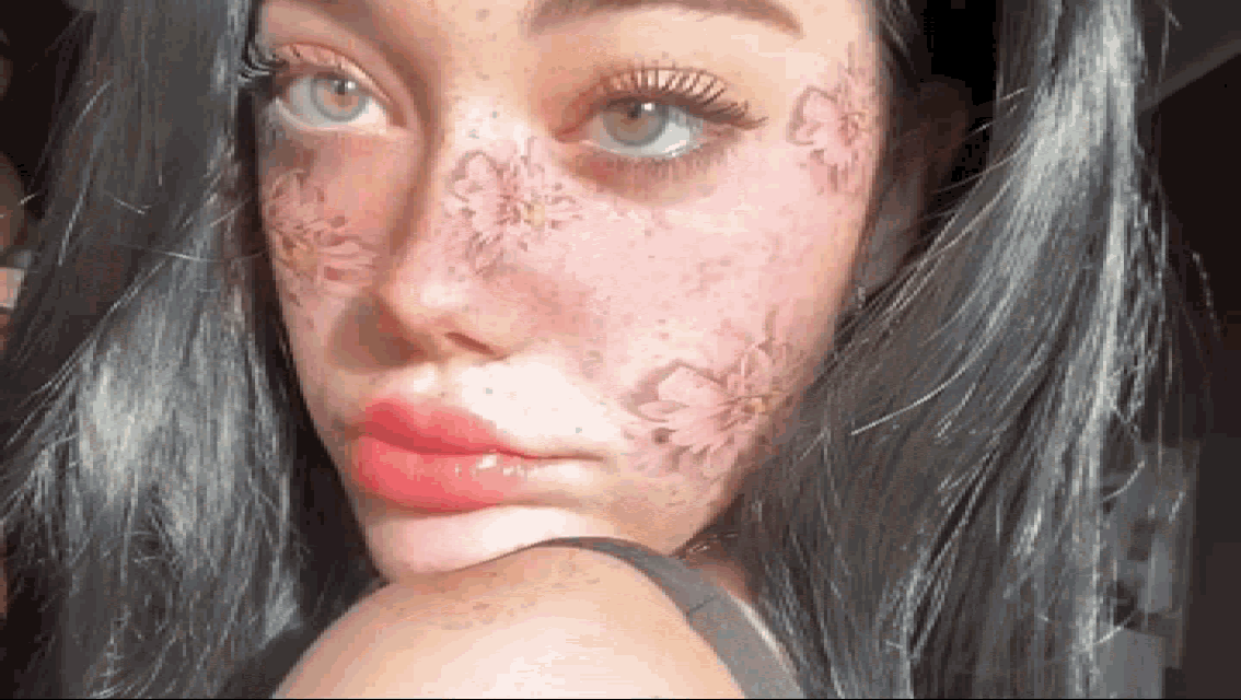 a close up of a woman 's face with flowers on her face