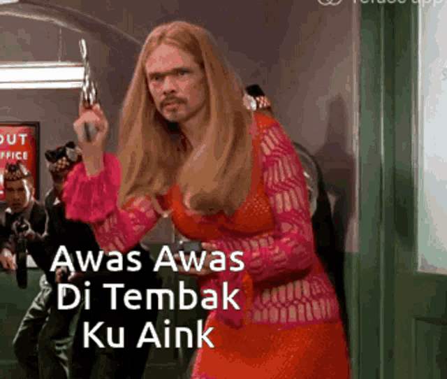a man in a red dress is holding a gun and says awas awas di tembak