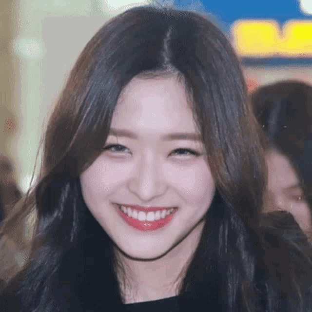 a close up of a woman 's face with a big smile .