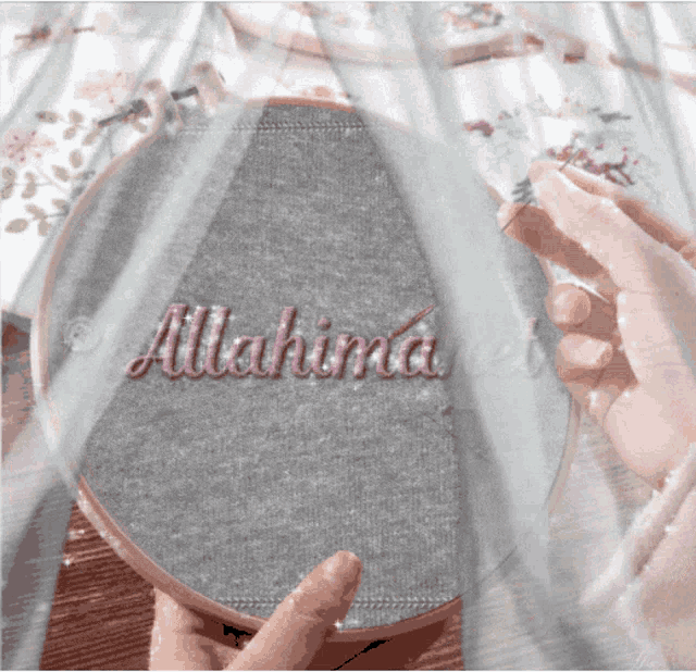 a person is holding an embroidery hoop that says allahima